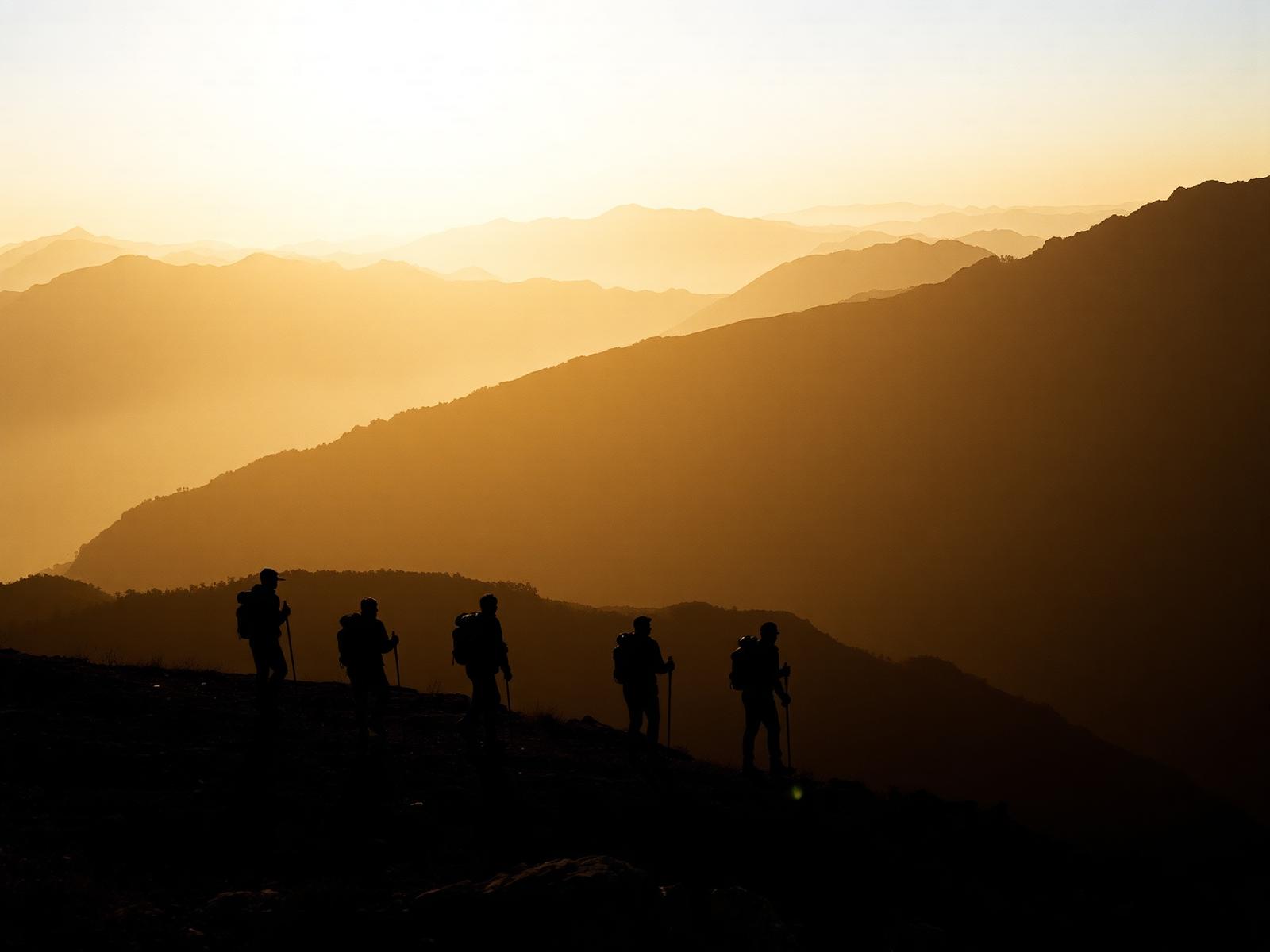Trekkers on a Himalayan ridge at golden hour